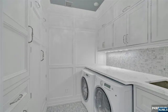 a utility room with cabinets washer and dryer