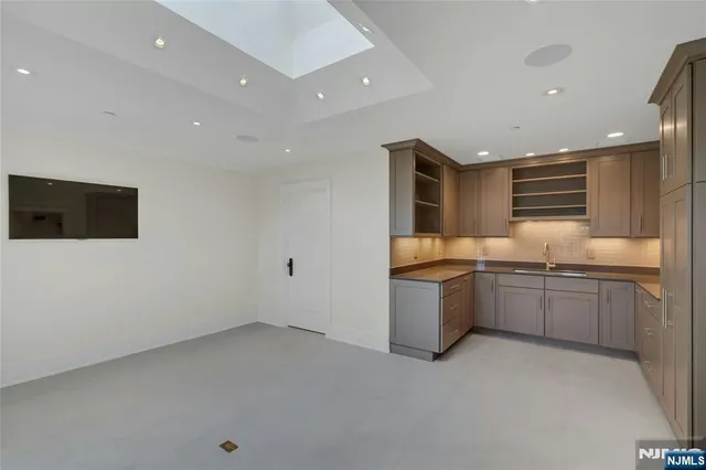 a large white kitchen with a large counter top space and stainless steel appliances