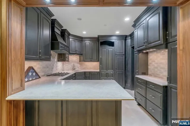 a kitchen with stainless steel appliances granite countertop a sink a stove and a refrigerator