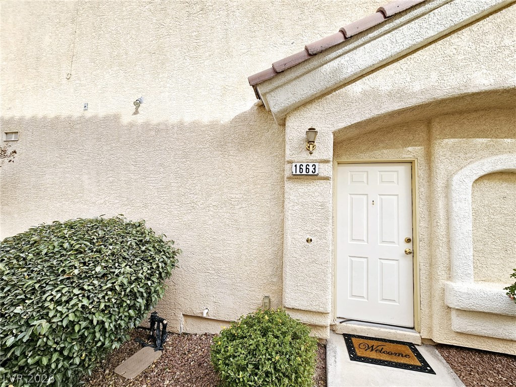 1663 Lefty Garcia Way Henderson, NV 89002 - Photo 26 of 31 A welcoming entry, with a classic front door and well-maintained shrubbery, presents inviting curb appeal.