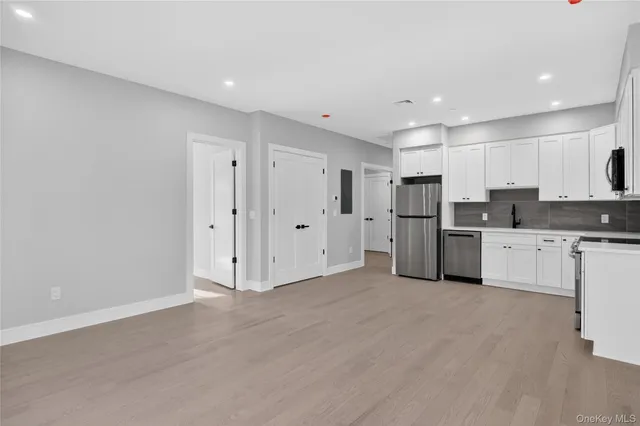 a view of a kitchen with a sink cabinets and stainless steel appliances