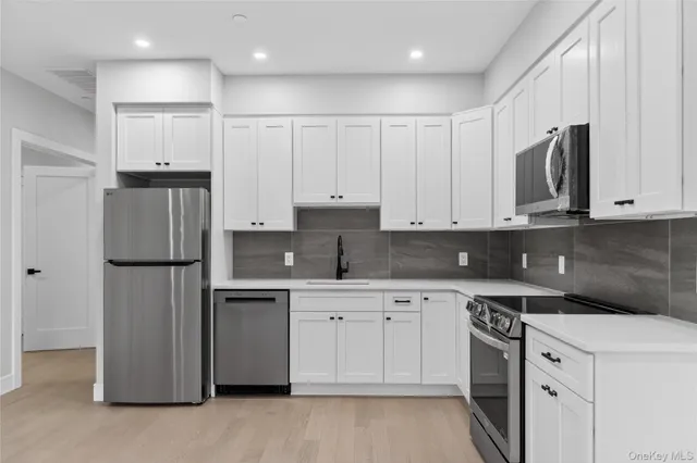 a kitchen with white cabinets and refrigerator