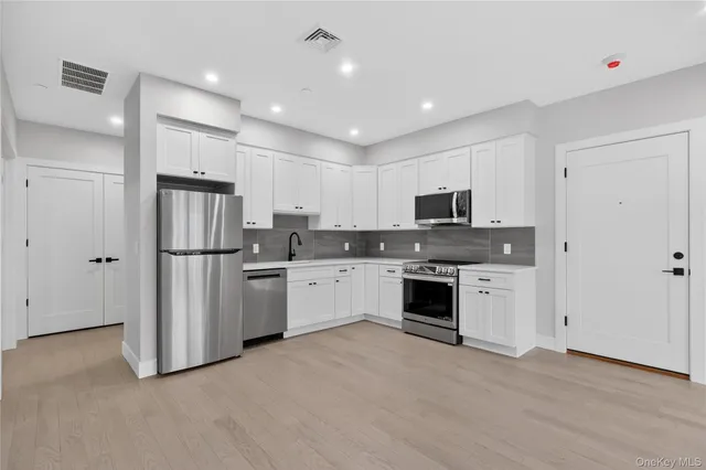 a kitchen with stainless steel appliances granite countertop a refrigerator oven a sink and dishwasher