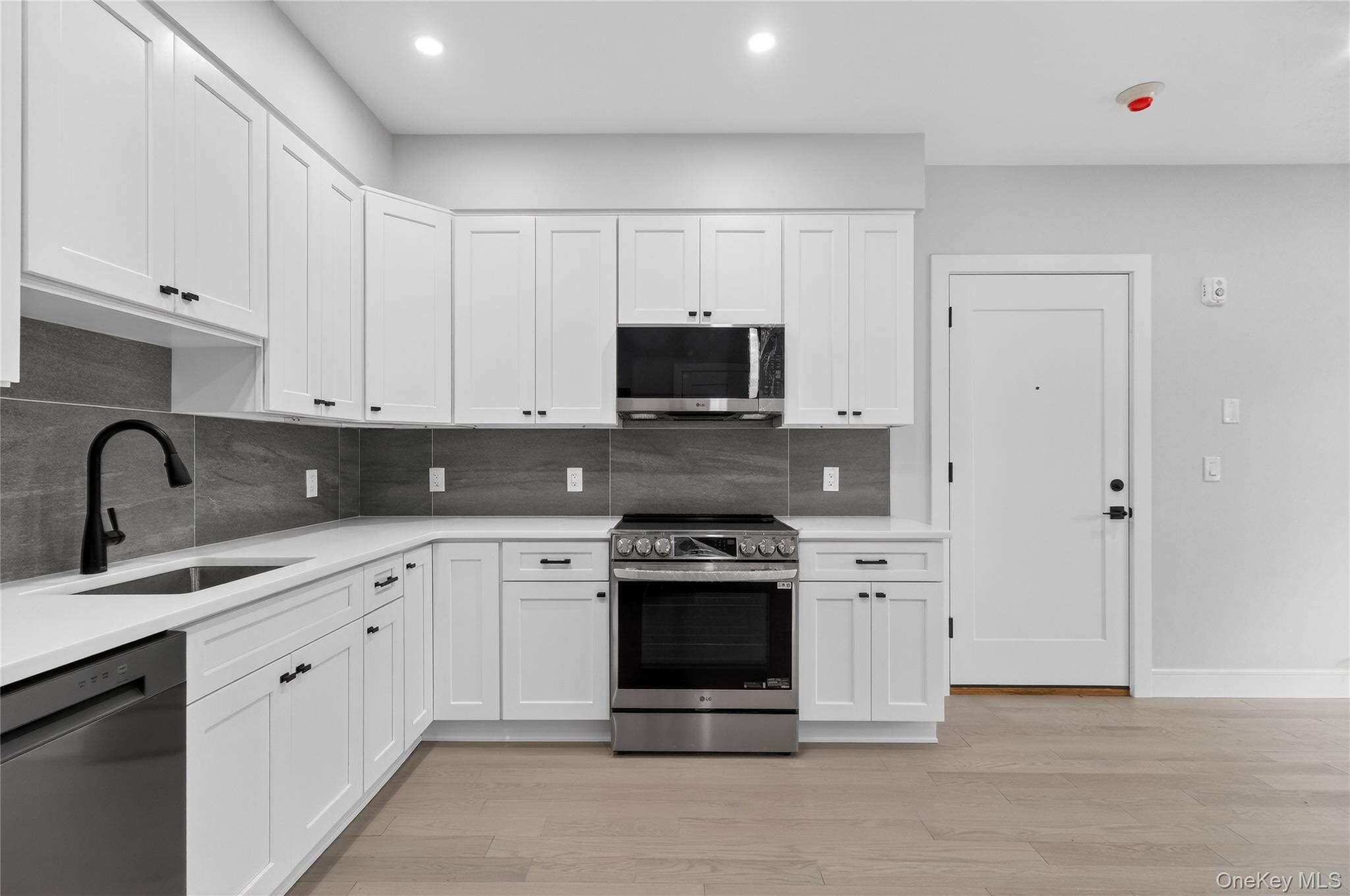 10 Market Street, Unit G Wappingers Falls, NY 12590 - Photo 4 of 20 a kitchen with white cabinets and stainless steel appliances
