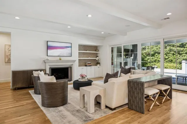 a living room with furniture a fireplace and a large window