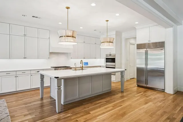 a kitchen with kitchen island a sink stainless steel appliances and cabinets