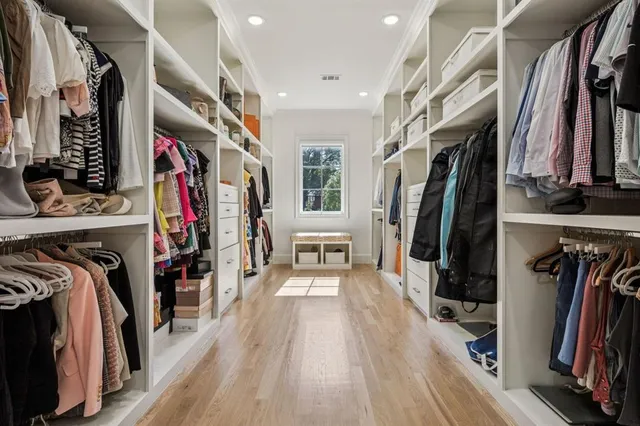 a view of walk in closet with clothes and shoes