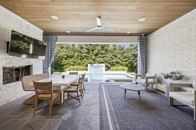 a outdoor space with chairs a couch and a flat screen tv