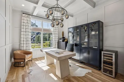 a kitchen with stainless steel appliances kitchen island granite countertop a refrigerator a stove and a dining table with wooden floor