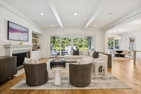 a living room with fireplace furniture and a large window
