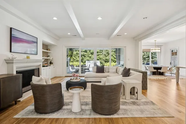a living room with fireplace furniture and a large window