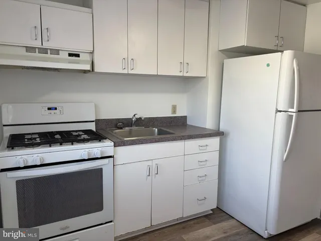a kitchen with cabinets appliances a sink and a stove