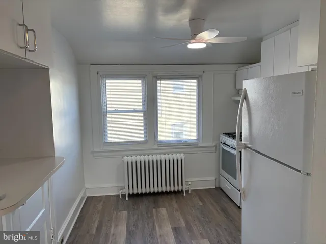 a view of empty room with a kitchen and a window