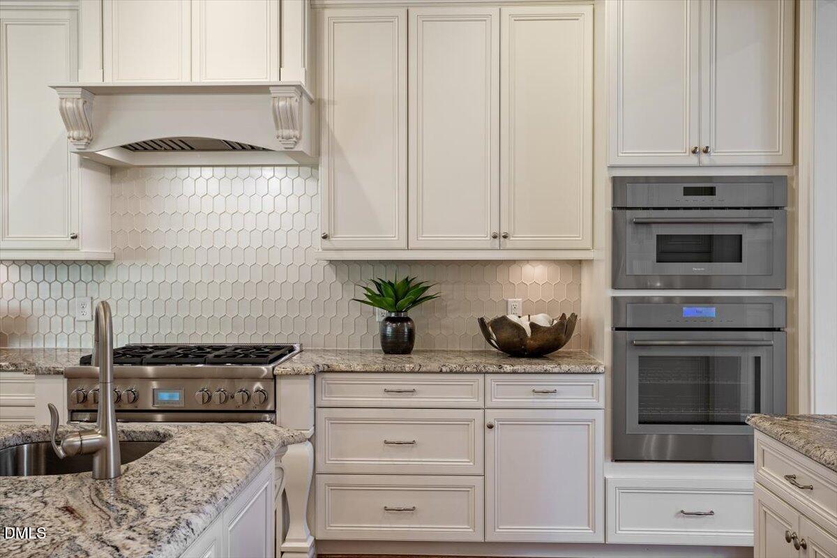 1413 Lily Estates Drive Raleigh, NC 27614 - Photo 27 of 82 a kitchen with white cabinets and appliances