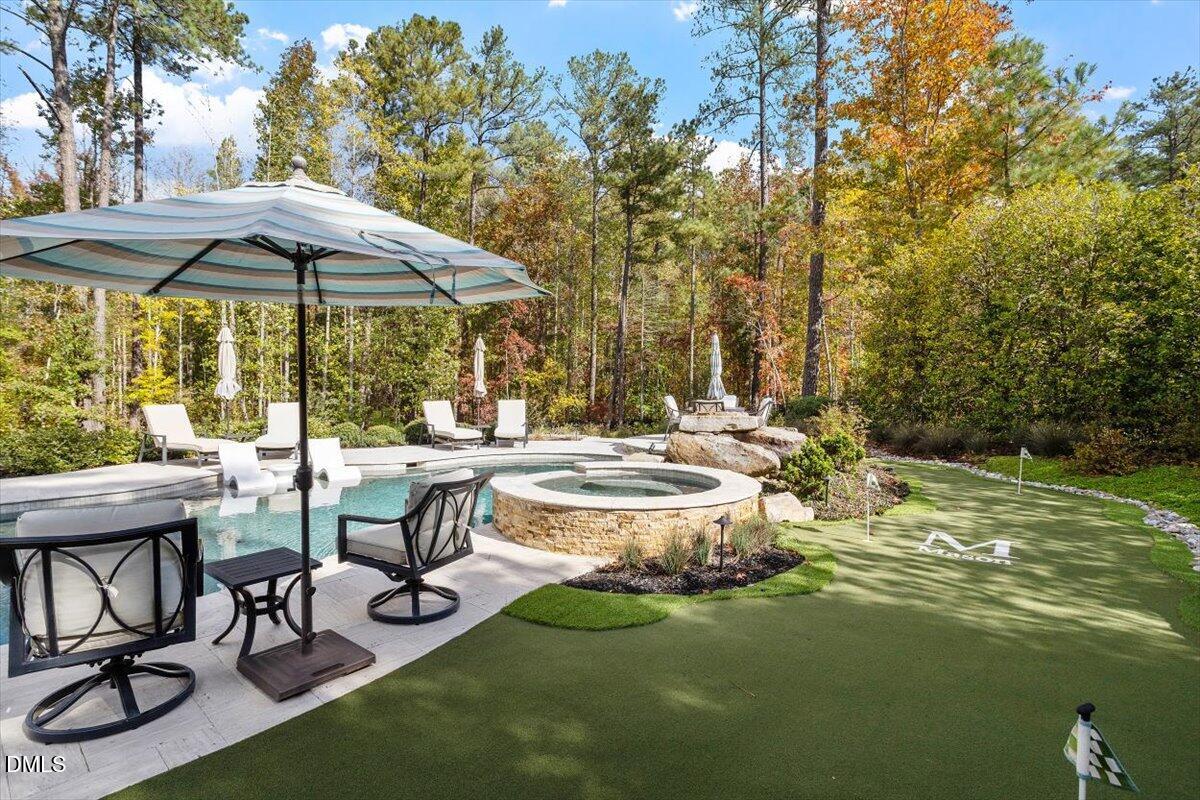 1413 Lily Estates Drive Raleigh, NC 27614 - Photo 71 of 82 a view of a swimming pool with lawn chairs under an umbrella