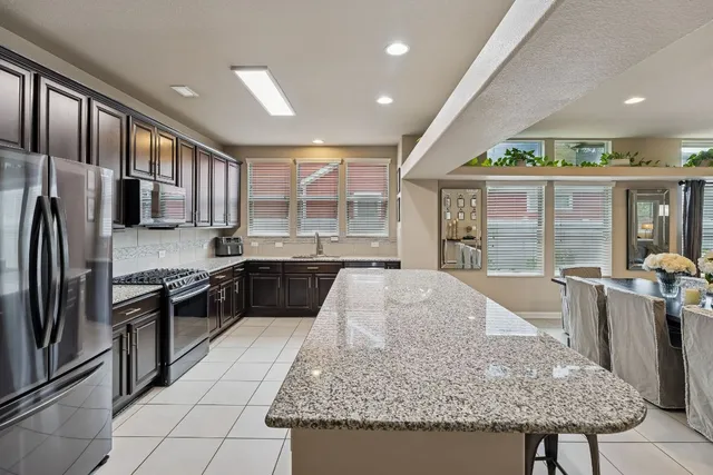 a kitchen with stainless steel appliances granite countertop a stove refrigerator and a sink