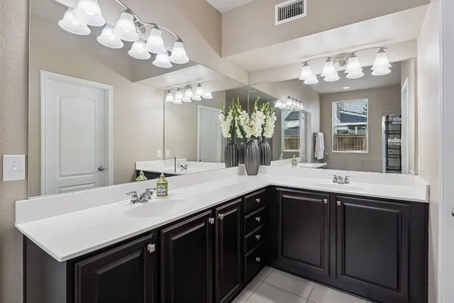 a bathroom with a sink a toilet a mirror and shower curtain