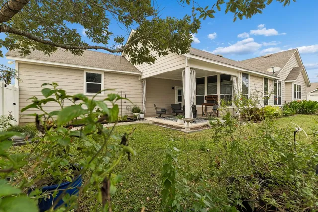 a view of a house with backyard sitting area and garden
