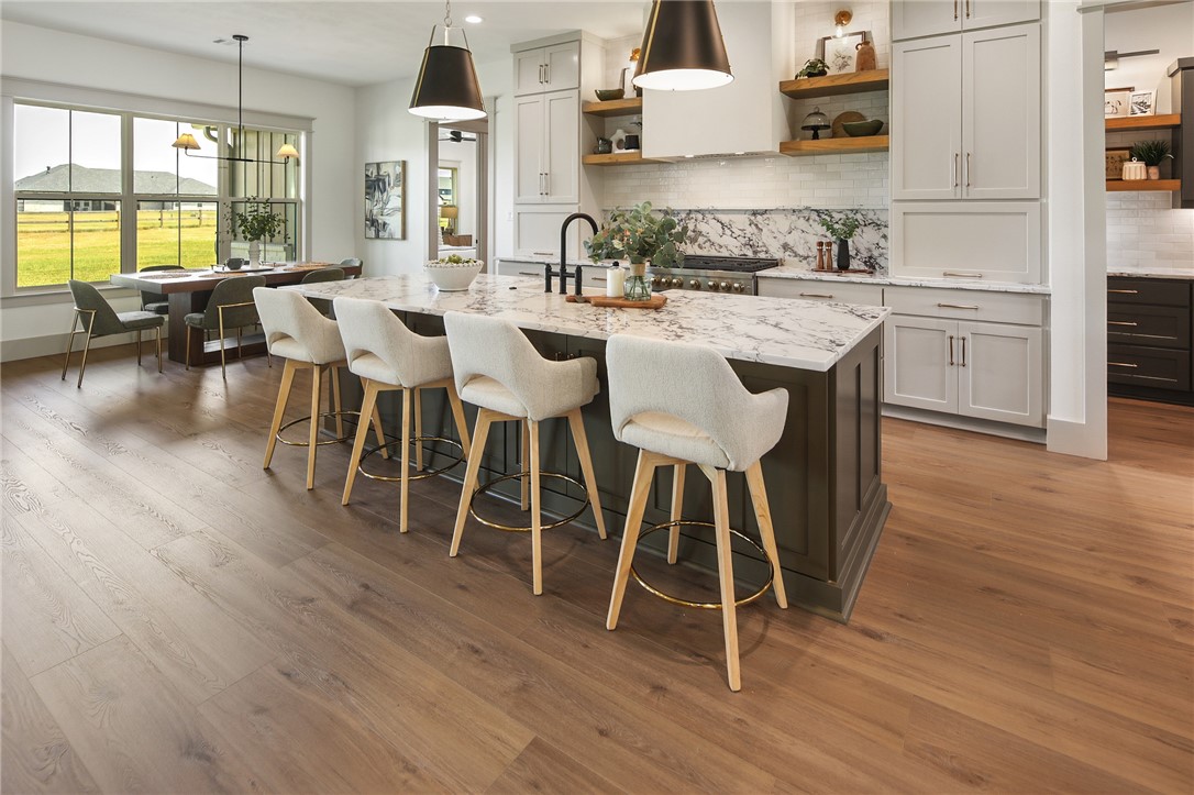 7933 Stiteler Drive Bryan, TX 77808 - Photo 5 of 44 a kitchen with stainless steel appliances granite countertop wooden floors and white counter top