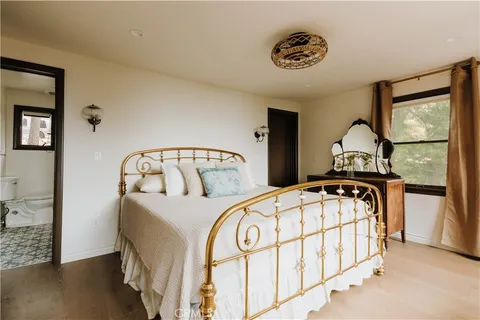 a bedroom with a bed a dresser and window