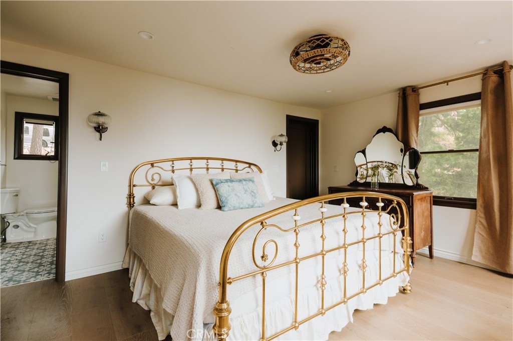 22771 Crest Forest Drive Crestline, CA 92325 - Photo 12 of 26 a bedroom with a bed a dresser and window