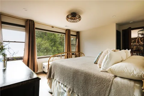 a bedroom with a bed and a large window