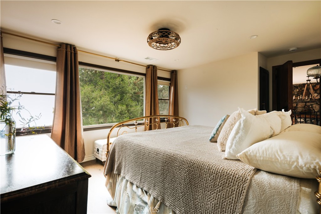 22771 Crest Forest Drive Crestline, CA 92325 - Photo 13 of 26 a bedroom with a bed and a large window