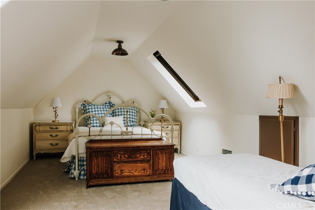 22771 Crest Forest Drive Crestline, CA 92325 - Photo 19 of 26 a bedroom with a bed and a chandelier