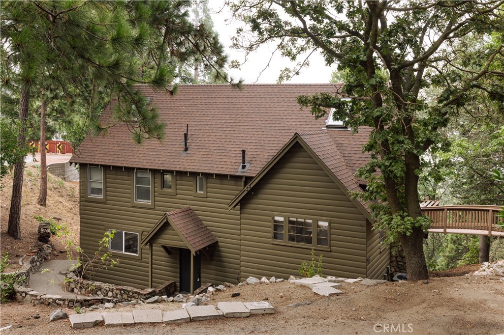 22771 Crest Forest Drive Crestline, CA 92325 - Photo 2 of 26 a front view of a house with garage