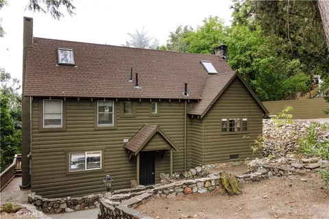 a front view of a house with a tree