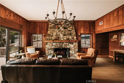 a living room with furniture a fireplace and a chandelier