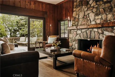 a living room with furniture a fireplace and a floor to ceiling window
