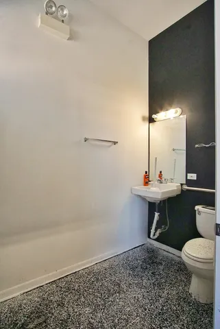 a bathroom with a toilet a sink and mirror