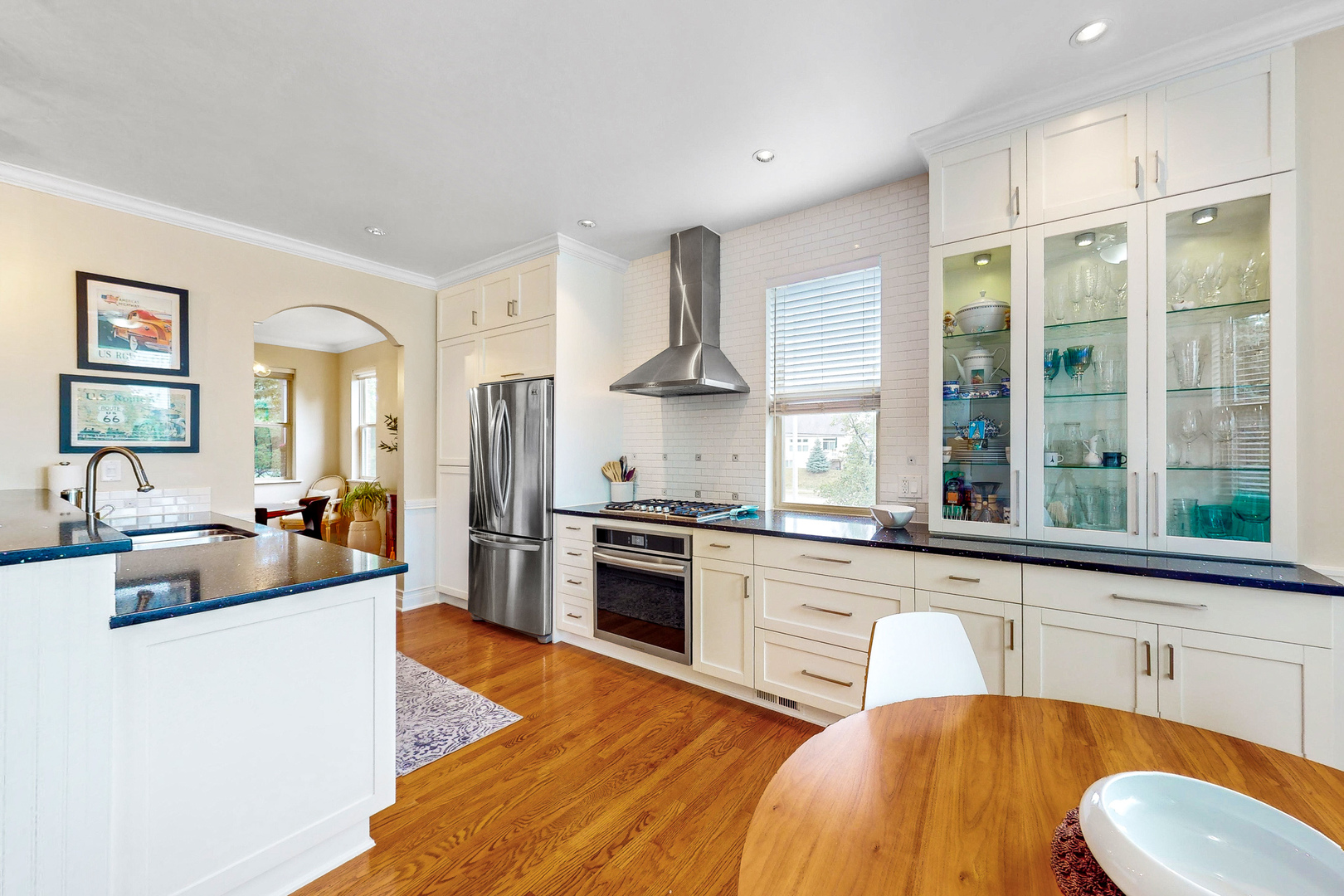 768 St Johns Place Addison, IL 60101 - Photo 9 of 34 a large kitchen with stainless steel appliances granite countertop a stove a sink dishwasher a dining table and chairs with wooden floor