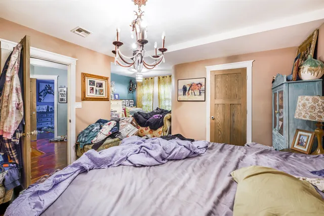 a bed room with a bed mirror and a tv