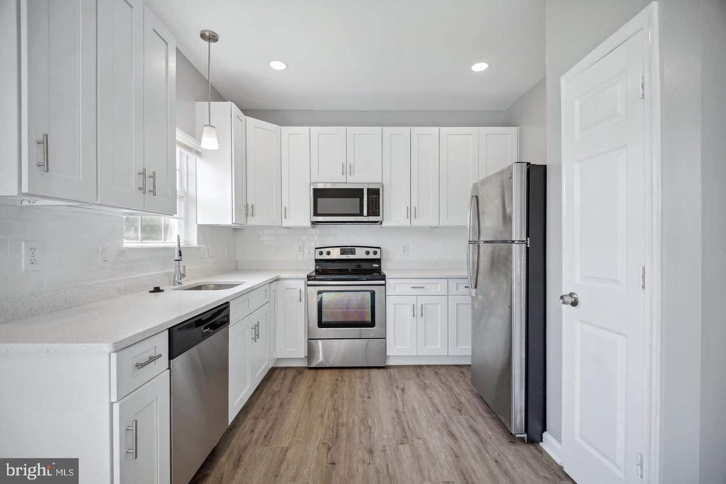 a kitchen with a sink a refrigerator a microwave and cabinets