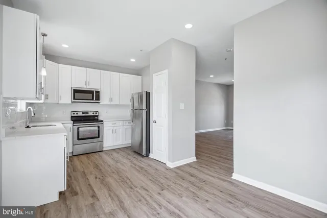 a kitchen with granite countertop a refrigerator and a stove top oven