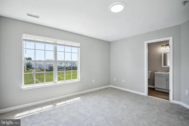 an empty room with windows and closet