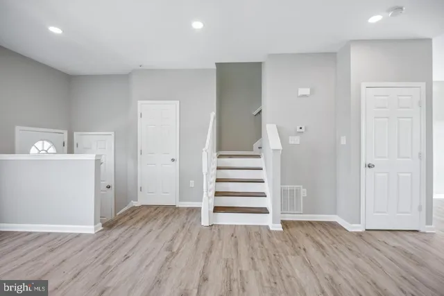 an empty room with wooden floor and white walls