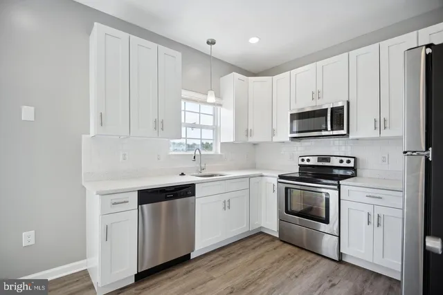 a kitchen with cabinets stainless steel appliances a sink and a microwave