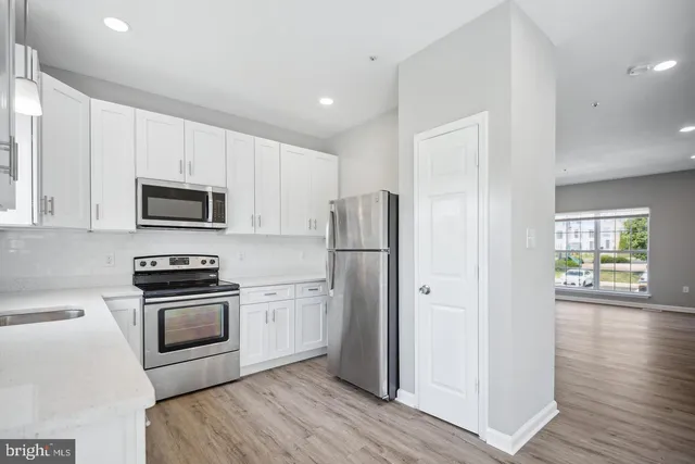 a kitchen with stainless steel appliances granite countertop a stove a refrigerator and a microwave