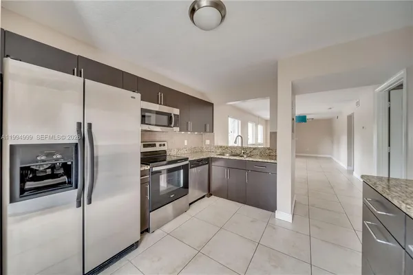 a kitchen with stainless steel appliances granite countertop a refrigerator and a sink