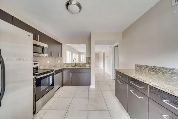 a modern kitchen with stainless steel appliances granite countertop a stove and a sink