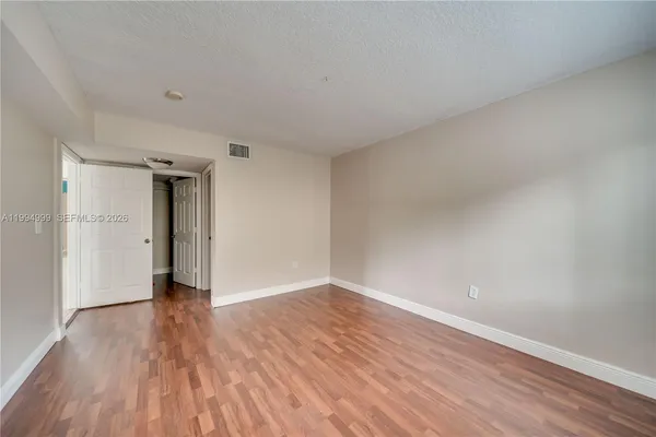 a view of an empty room with wooden floor