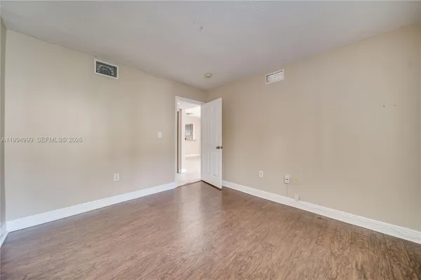 a view of an empty room with wooden floor