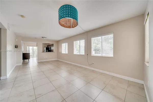 an empty room with windows and ceiling fan