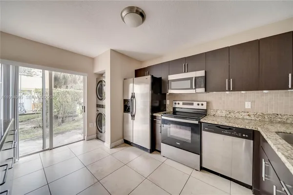 a kitchen with stainless steel appliances granite countertop a stove a sink and a refrigerator