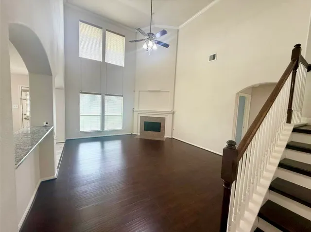 a view of a livingroom with wooden floor and staircase