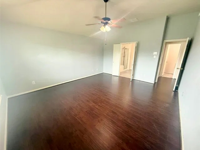 an empty room with wooden floor and door