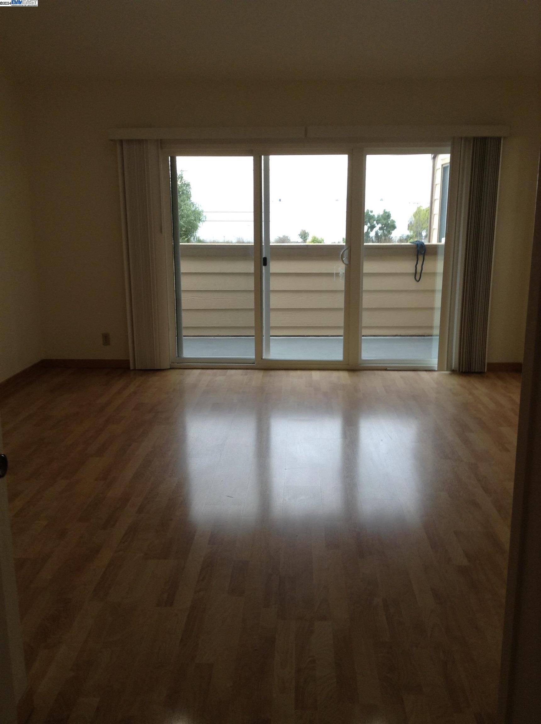 1064 Dempsey Road Milpitas, CA 95035 - Photo 13 of 31 a view of an empty room with wooden floor and a window